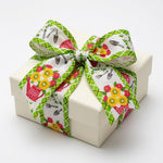 Load image into Gallery viewer, A square cream gift box topped with an intricate, structured multi-loop bow crafted from the white and green plaid garden-themed wired ribbon.
